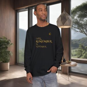 2533890360291418158_2048_customjpeg - Essence Innovation Man in a black long-sleeve shirt with gold text stands in a modern room with wooden walls and a large window showing mountains outside.