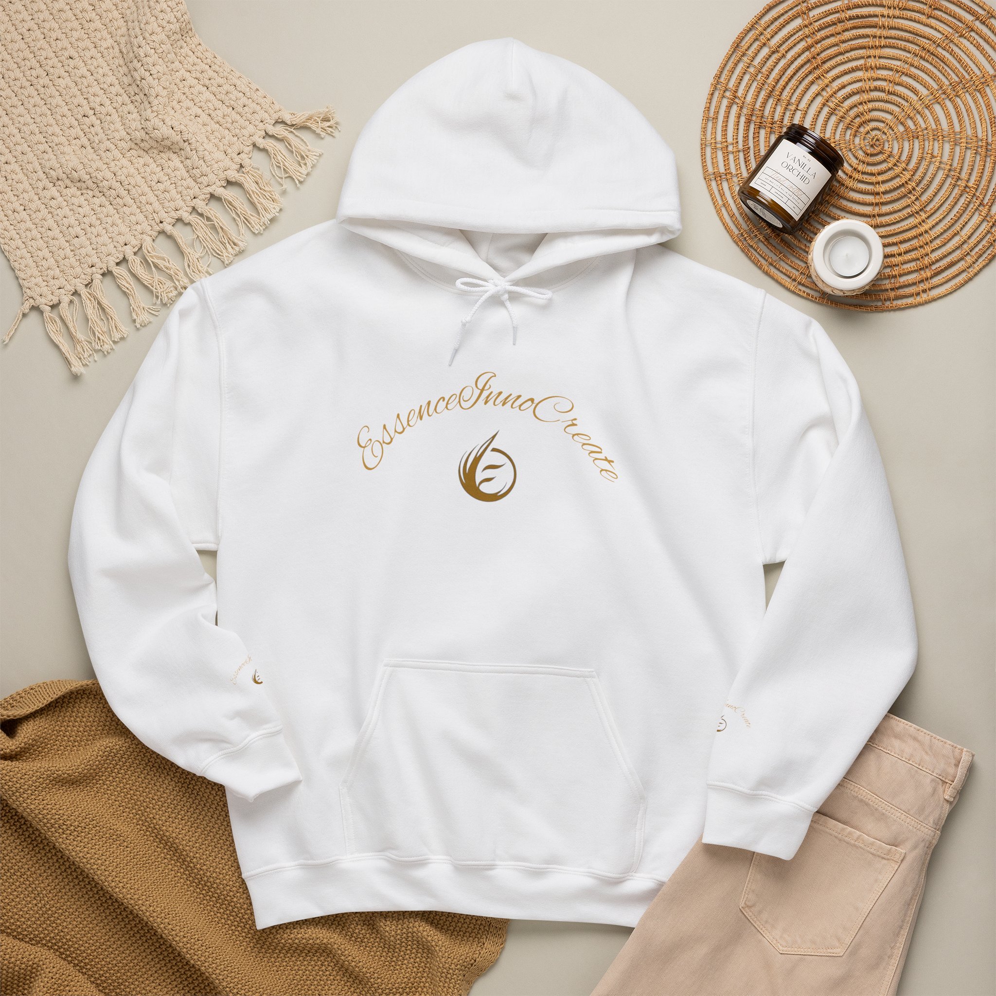293048773325186288_2048jpeg - Essence Innovation Flat lay of a white hoodie surrounded by a beige textured scarf, a woven placemat, and a candle jar on a neutral background, showcasing a casual outfit setup.