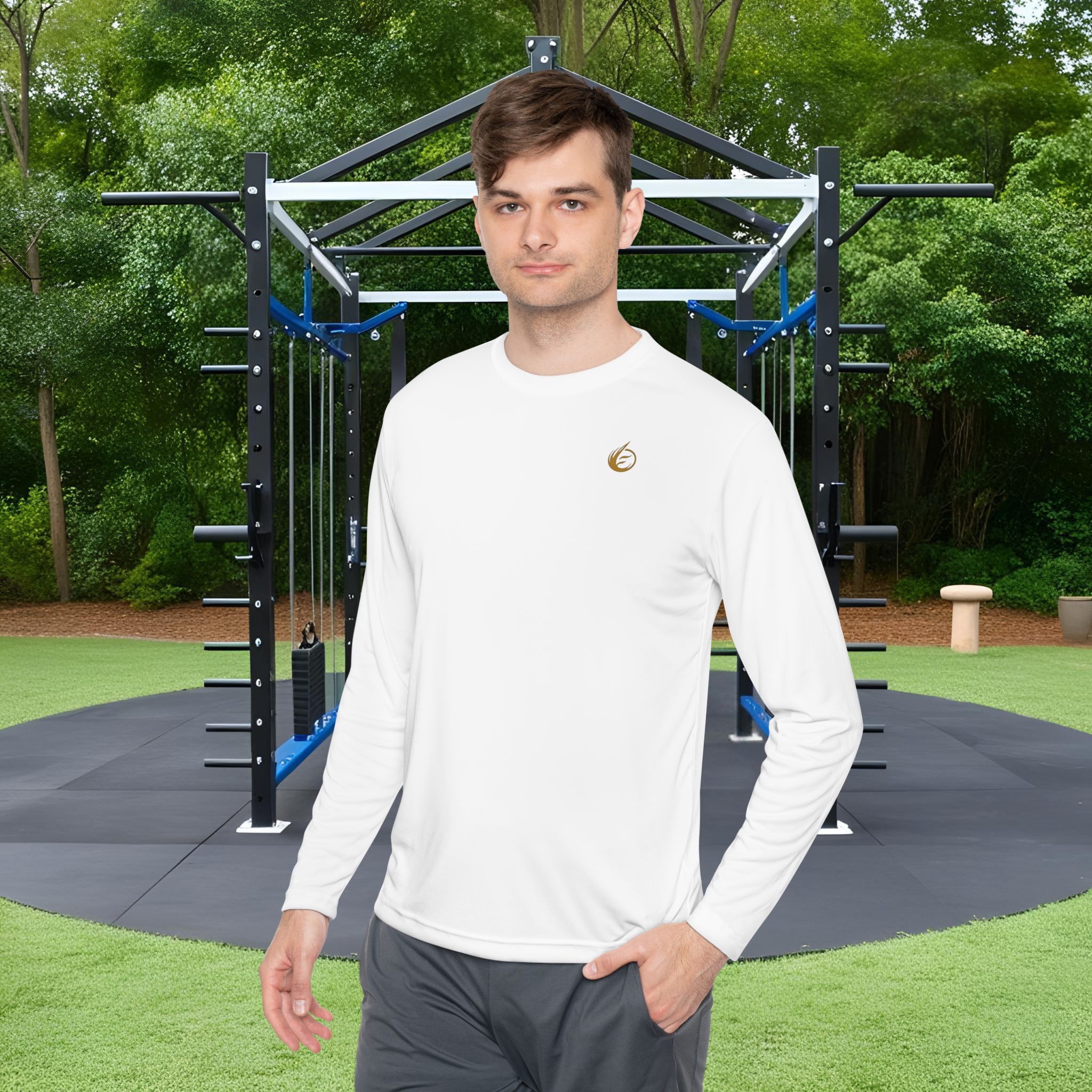 3244399824425845599_2048_customjpeg - Essence Innovation Man in a white long-sleeve shirt standing in front of a black metal outdoor gym rig in a park with green trees behind him.
