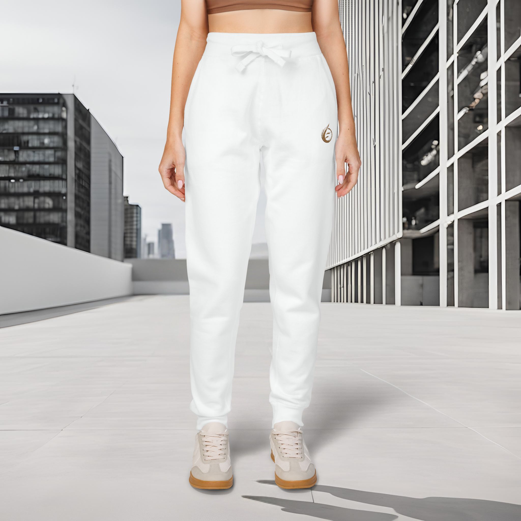 35959067796712158_2048_customjpeg - Essence Innovation Person standing outdoors in white drawstring pants and beige sneakers on a tiled rooftop with a metal railing in the background, urban setting.