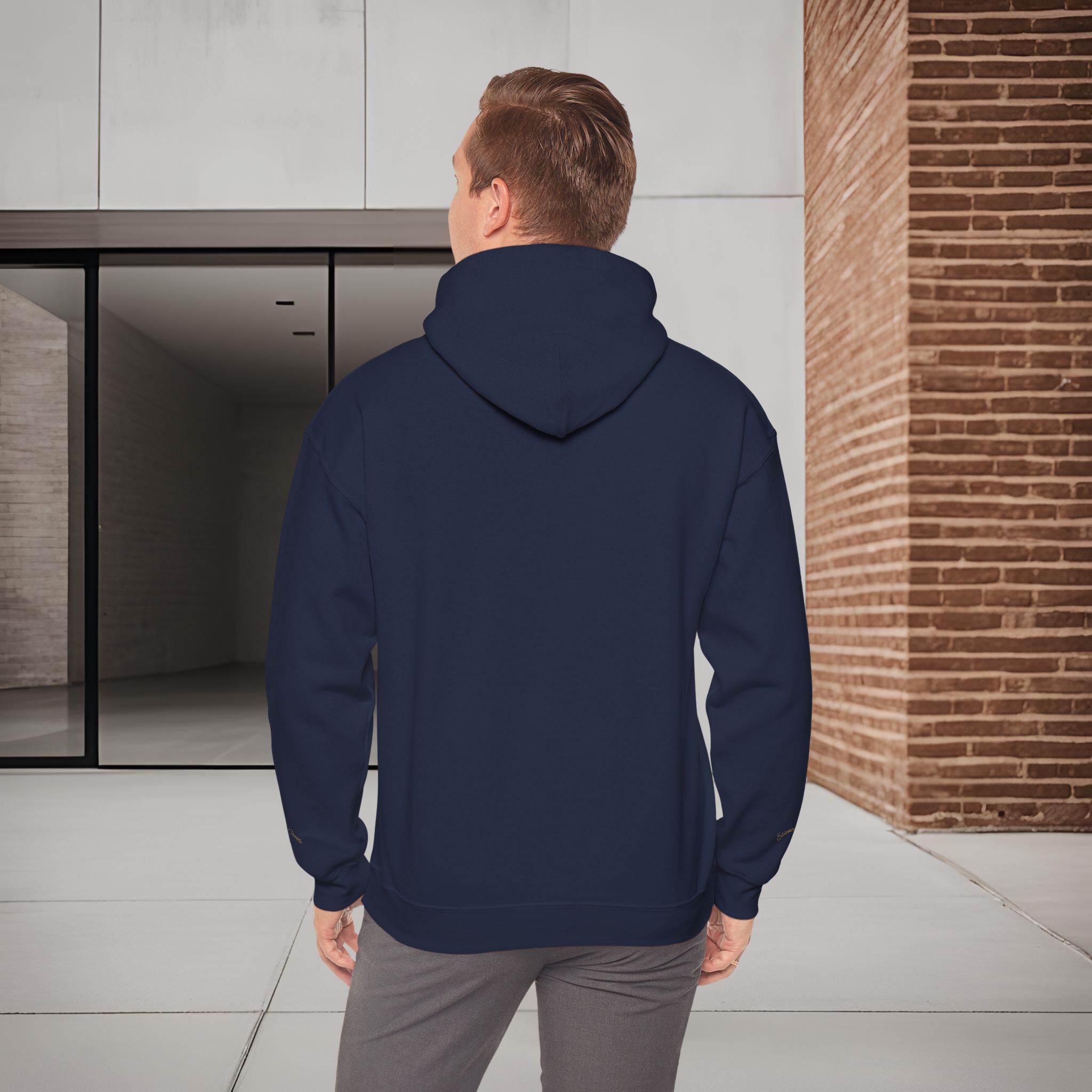 3619208145423965145_2048_customjpeg - Essence Innovation Person seen from behind wearing a navy hooded jacket, standing beside a glass door and a brick wall.
