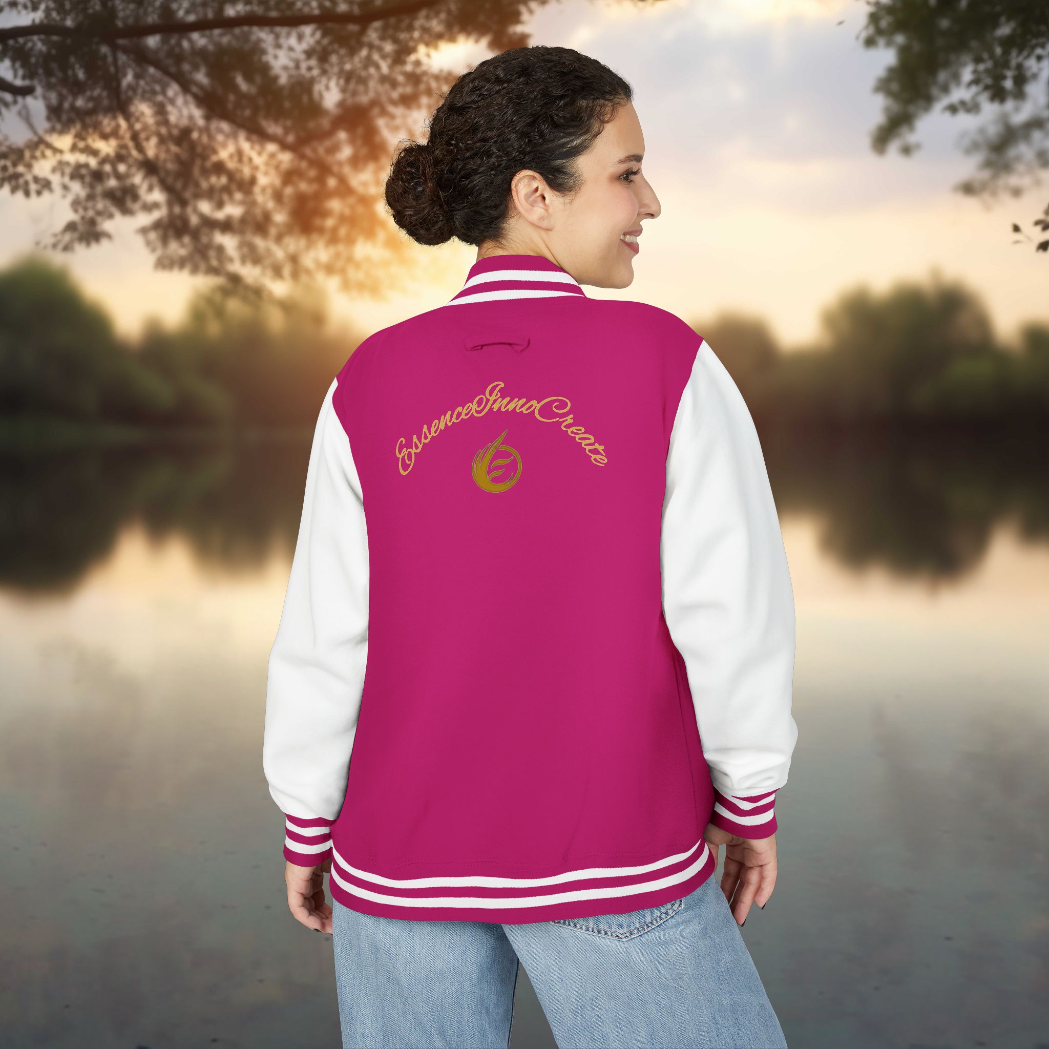 4670625904992951291_2048_customjpeg - Essence Innovation Person seen from behind wearing a pink varsity jacket with white sleeves and striped cuffs, outdoors at sunset.