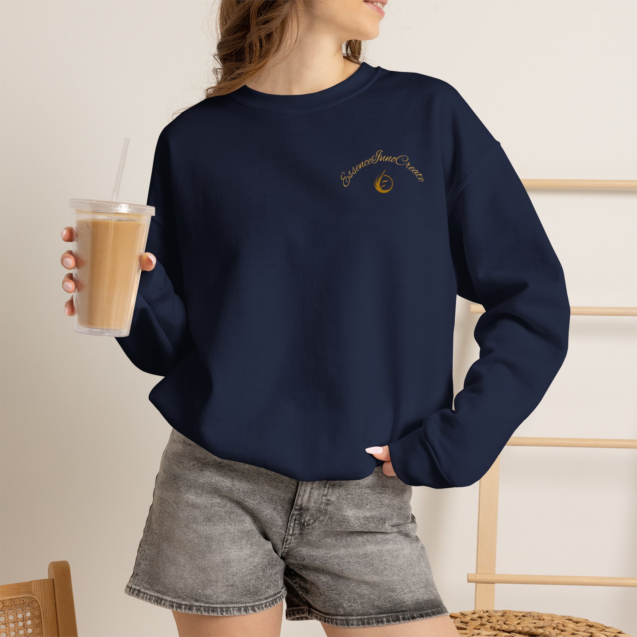 6816583780487987198_2048jpeg - Essence Innovation Person wearing a navy sweatshirt with a small gold logo on the chest, holding a iced coffee in a clear cup with a straw.