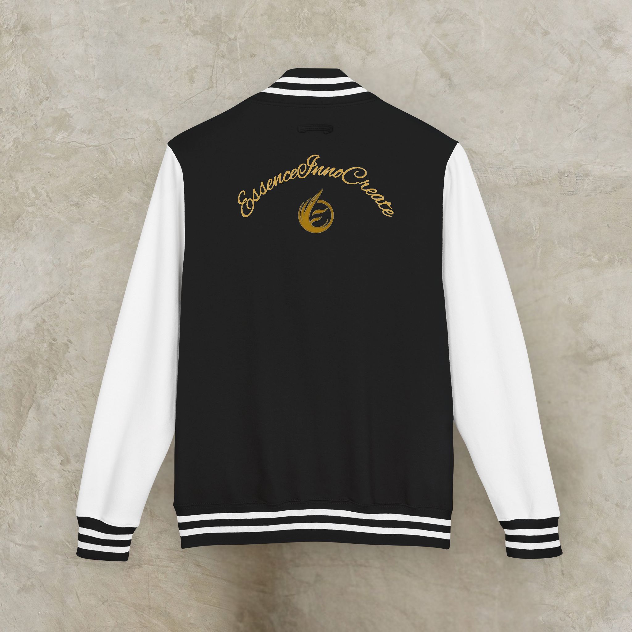 816957320825068885_2048_customjpeg - Essence Innovation Back view of a black varsity jacket with white sleeves and striped cuffs; gold cursive logo on the back.